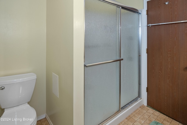 bathroom featuring walk in shower and toilet