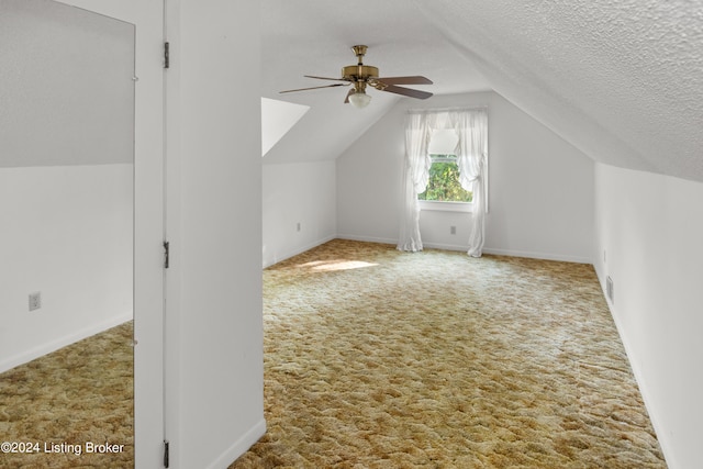 additional living space featuring ceiling fan, carpet flooring, a textured ceiling, and vaulted ceiling