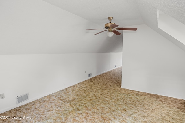 bonus room with lofted ceiling, ceiling fan, carpet, and a textured ceiling