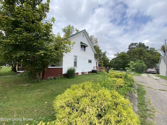 view of home's exterior with a yard and central AC