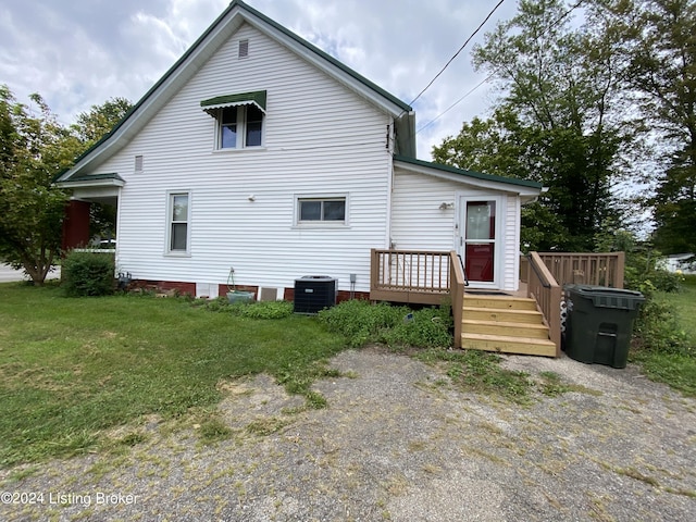 rear view of property featuring a yard, central air condition unit, and a deck