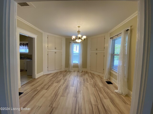 unfurnished dining area featuring ornamental molding, a chandelier, and light wood-type flooring