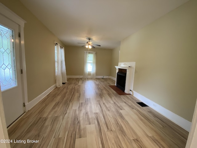 unfurnished living room featuring ceiling fan and light hardwood / wood-style flooring