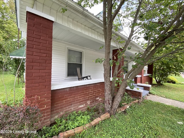 view of side of property featuring a yard and a porch