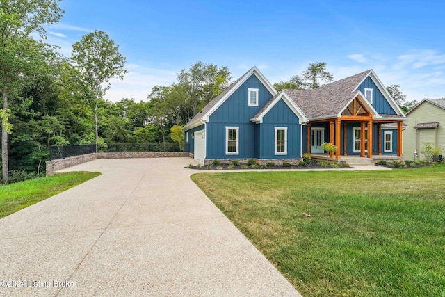 view of front facade featuring board and batten siding, an attached garage, driveway, and a front lawn