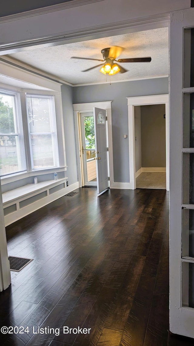 empty room with ceiling fan, ornamental molding, hardwood / wood-style floors, and a textured ceiling