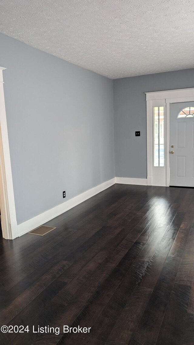 spare room featuring a textured ceiling and wood-type flooring