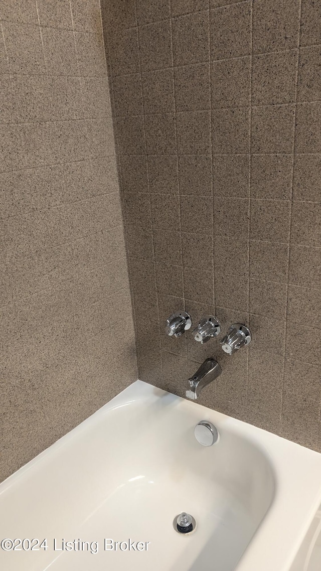 interior details with tiled shower / bath combo