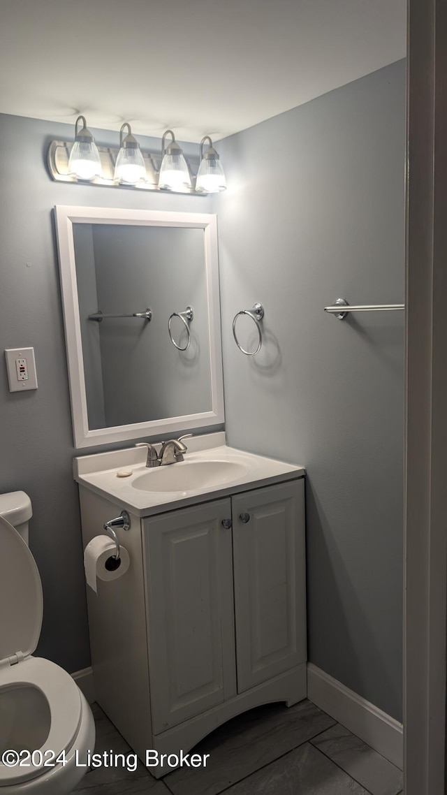 bathroom featuring tile patterned floors, vanity, and toilet