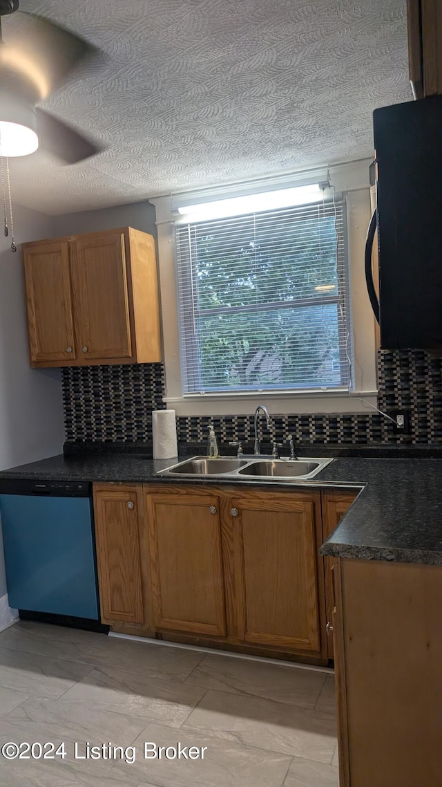 kitchen featuring stainless steel dishwasher, decorative backsplash, sink, a textured ceiling, and light tile patterned floors