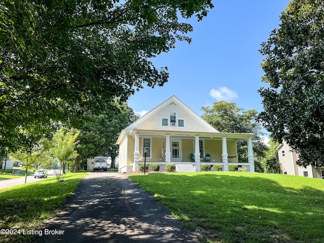 view of front of house with a porch and a front lawn