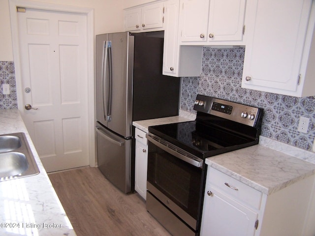 kitchen with electric range, light hardwood / wood-style flooring, sink, and white cabinetry