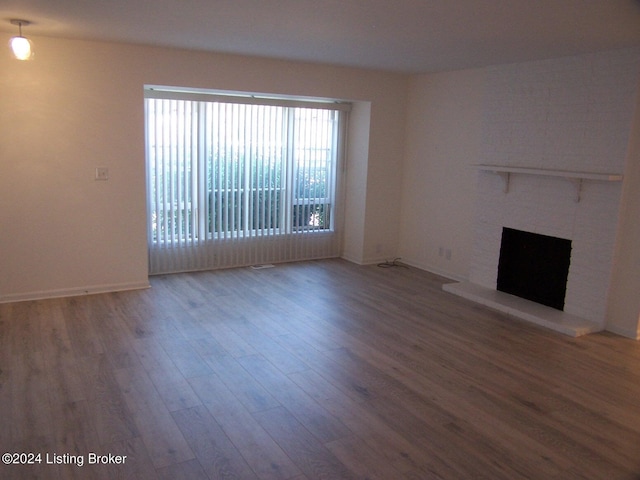 unfurnished living room with a fireplace and hardwood / wood-style floors