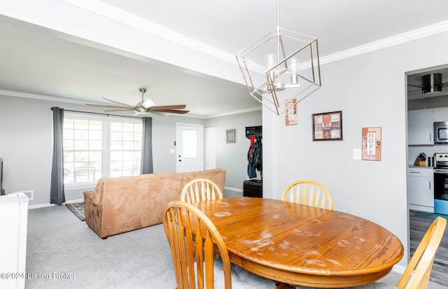 carpeted dining area featuring ceiling fan with notable chandelier and ornamental molding