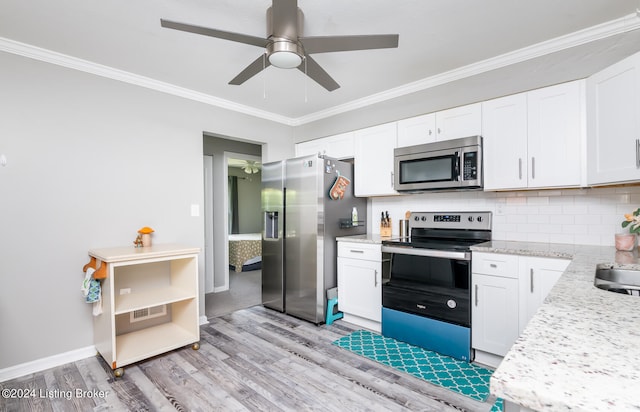 kitchen with appliances with stainless steel finishes, white cabinets, and tasteful backsplash