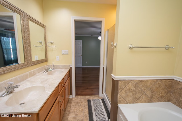 bathroom with ornamental molding, hardwood / wood-style floors, plus walk in shower, and vanity