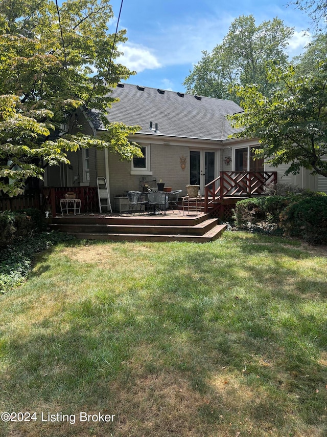 rear view of house featuring a yard and a wooden deck