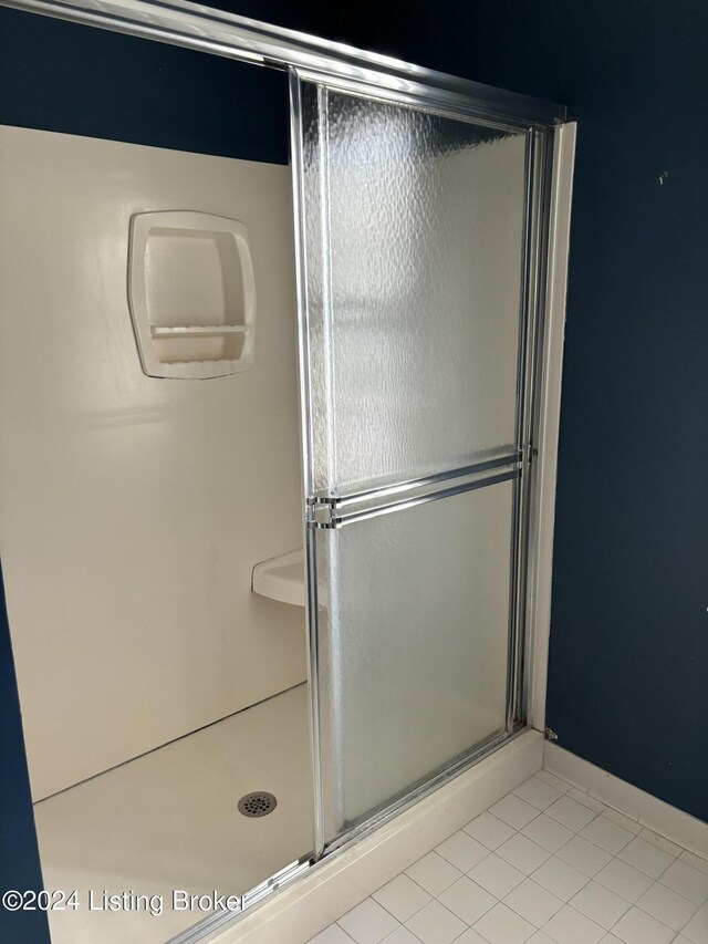 bathroom with tile patterned floors and a shower with shower door