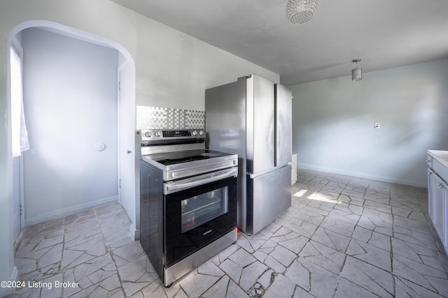 kitchen featuring white cabinets, backsplash, light tile patterned floors, and stainless steel appliances