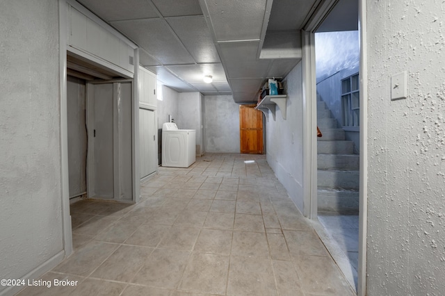 corridor with washer / clothes dryer, light tile patterned floors, and a drop ceiling