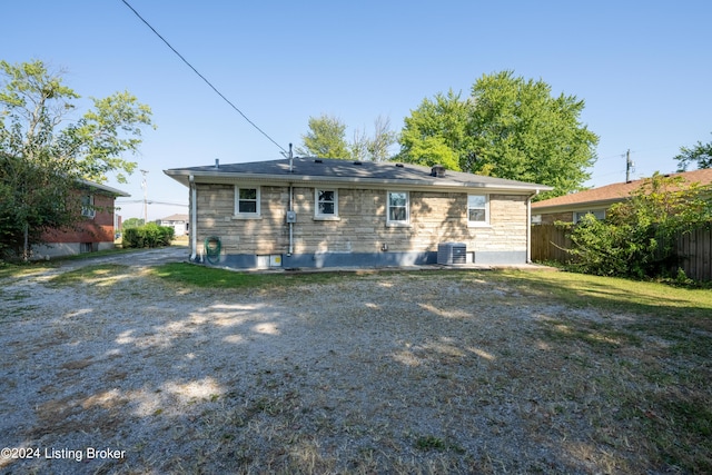 rear view of property with a lawn and central AC