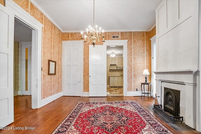 interior space with hardwood / wood-style floors, a notable chandelier, and ornamental molding