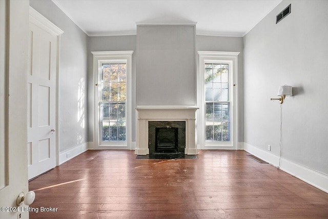 unfurnished living room with crown molding, plenty of natural light, and dark wood-type flooring