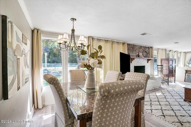 dining space with a notable chandelier, a textured ceiling, and a wealth of natural light