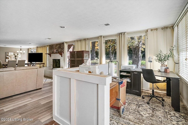 interior space with a fireplace, a chandelier, light hardwood / wood-style floors, and a textured ceiling