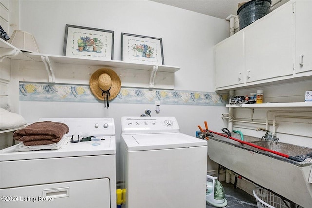 laundry room with cabinets, washing machine and dryer, and sink