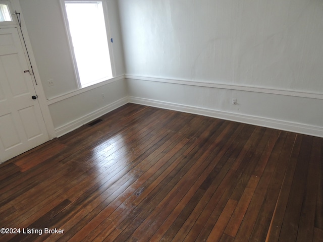 unfurnished room with dark hardwood / wood-style flooring