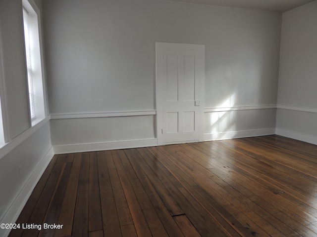 unfurnished room with dark hardwood / wood-style flooring