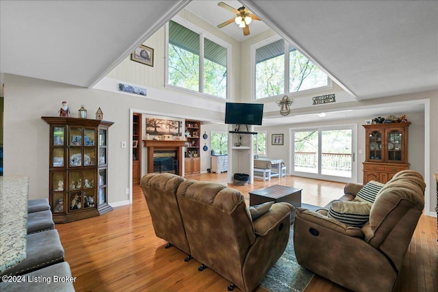 living room with light hardwood / wood-style flooring, a high ceiling, and a healthy amount of sunlight