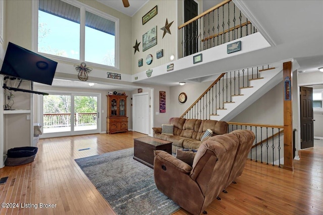 living room with light hardwood / wood-style flooring and a towering ceiling