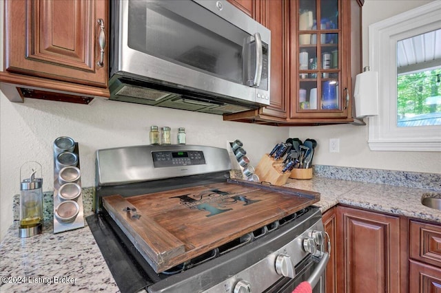 kitchen featuring light stone counters and stainless steel appliances