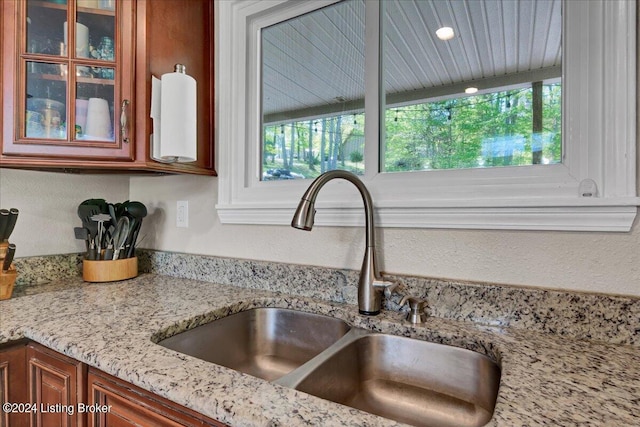 interior details featuring light stone countertops and sink