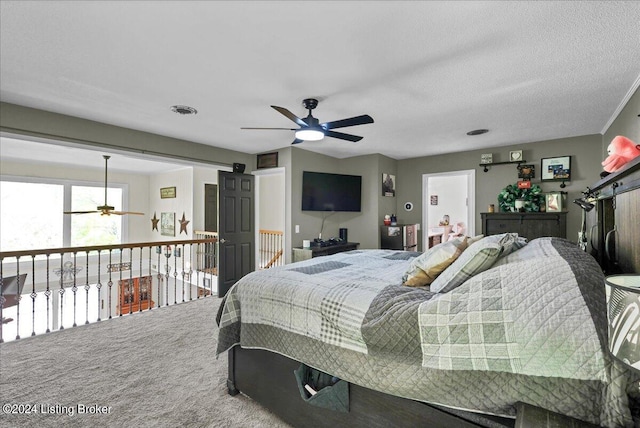 carpeted bedroom featuring ceiling fan and a textured ceiling