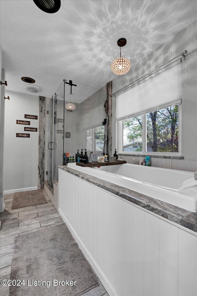 kitchen with light tile patterned flooring, a textured ceiling, and hanging light fixtures