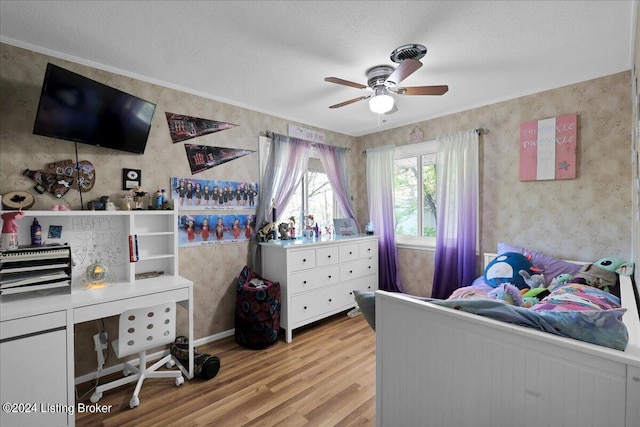 bedroom with light hardwood / wood-style flooring, a textured ceiling, and ceiling fan