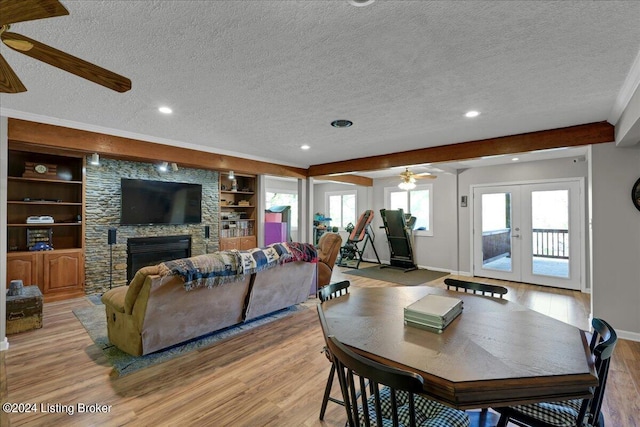 dining space featuring a textured ceiling, built in shelves, ceiling fan, and light hardwood / wood-style floors