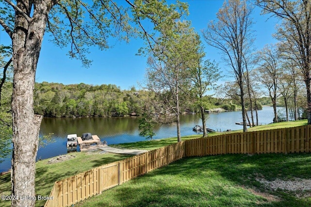 view of dock with a lawn and a water view