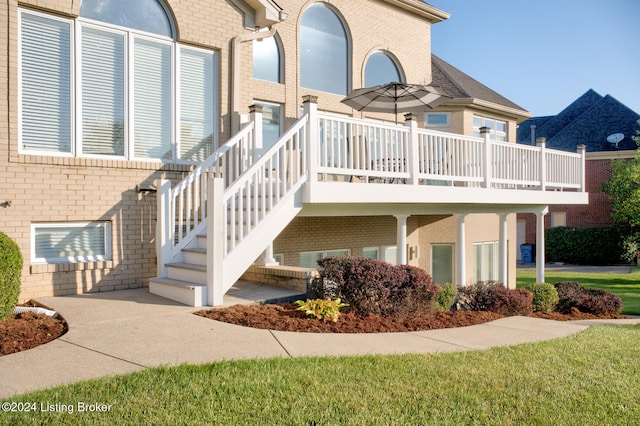 exterior space with a deck and a lawn