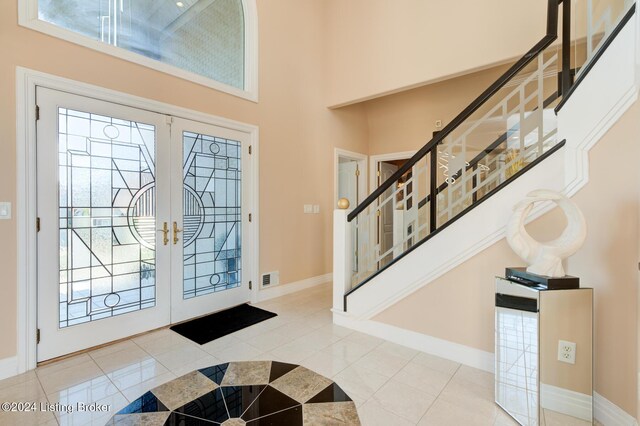 entrance foyer featuring light tile patterned floors, a wealth of natural light, and french doors