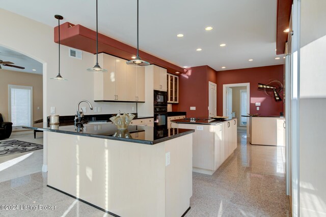 kitchen with sink, a kitchen island, ceiling fan, kitchen peninsula, and black appliances