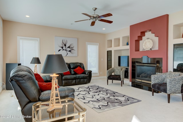 living room with ceiling fan, built in features, and carpet flooring