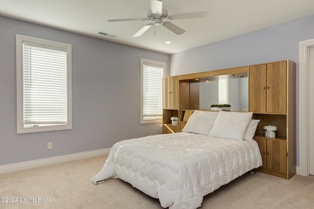 bedroom with ceiling fan and light carpet