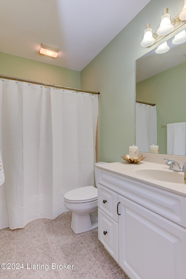 bathroom featuring tile patterned flooring, toilet, and vanity