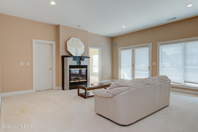 carpeted living room featuring a multi sided fireplace and plenty of natural light