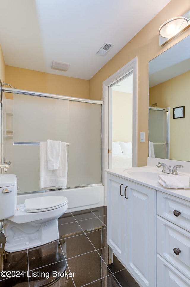 full bathroom featuring tile patterned floors, toilet, vanity, and bath / shower combo with glass door