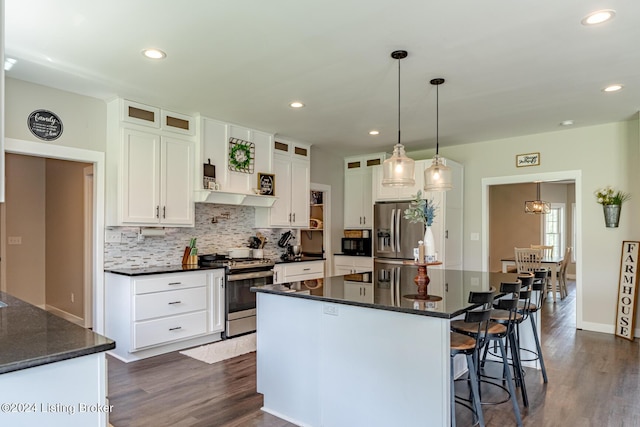 kitchen featuring stainless steel appliances, hanging light fixtures, glass insert cabinets, white cabinets, and a kitchen island